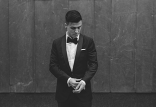 A groom fixing his cufflinks before the wedding ceremony at Four Seasons Hotel 